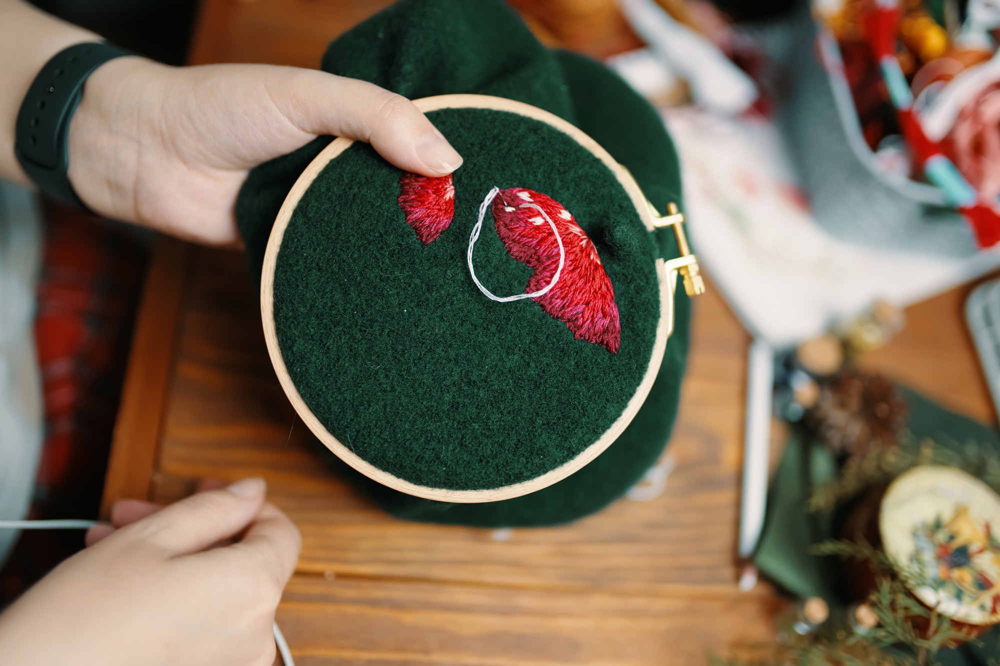 hands holding an embroidered hoop with geometric motif